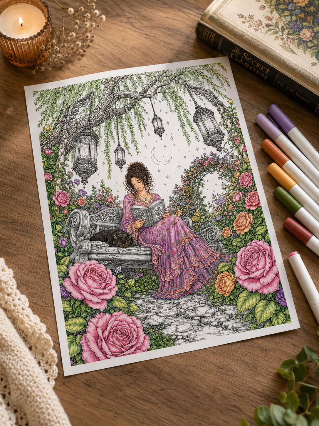 Colored secret garden illustration of a woman reading beside a sleeping cat among pink roses, on a wooden table with markers and a candle.